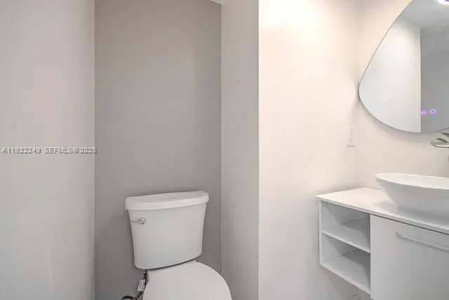 a white toilet sitting next to a bathroom sink