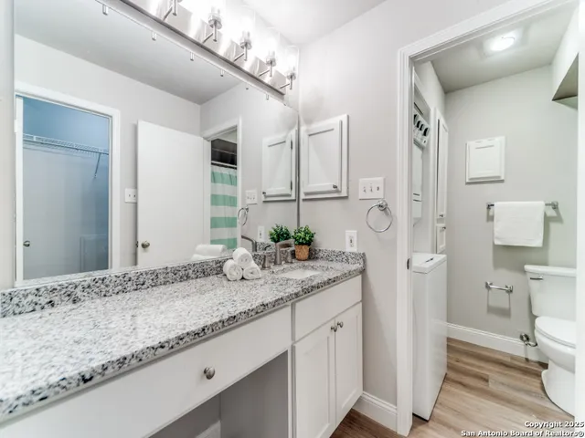 a bathroom with a granite countertop sink a toilet and a mirror