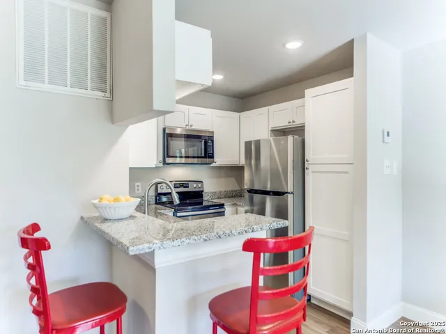 a kitchen with stainless steel appliances granite countertop a refrigerator and a sink