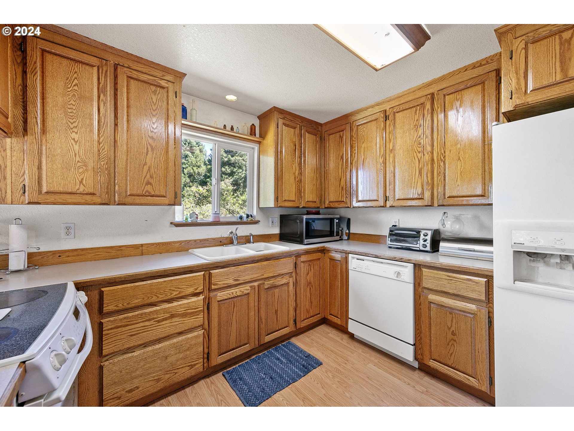 6551 Elkhead Road Yoncalla, OR 97499 - Photo 14 of 39 a kitchen with stainless steel appliances granite countertop wooden cabinets a sink and a large window