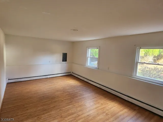 a view of a room with wooden floor and window
