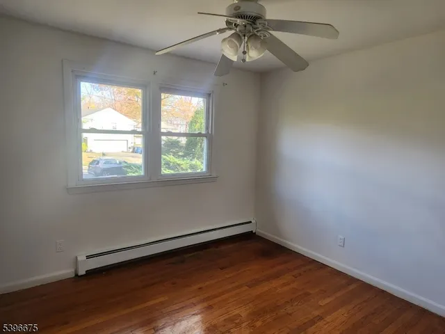 an empty room with a window and wooden floor