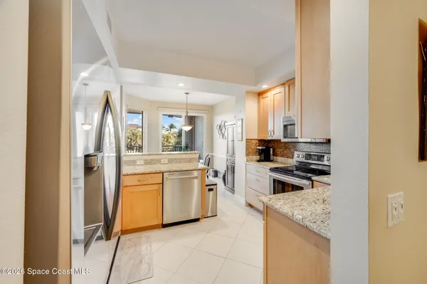 a kitchen with stainless steel appliances granite countertop white cabinets a stove top oven with a sink and dishwasher