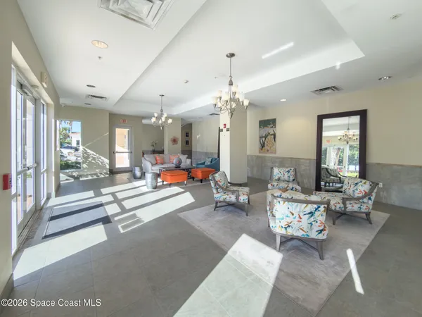 a living room with furniture a chandelier and a window