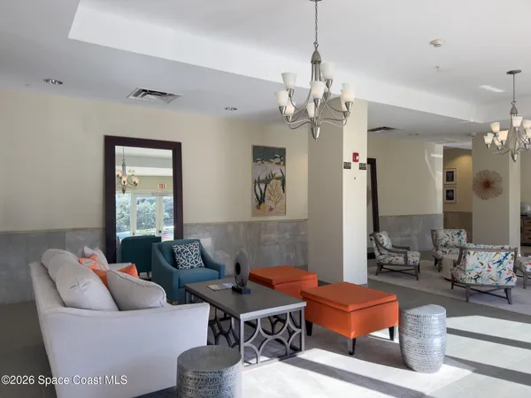a living room with furniture a chandelier and a mirror