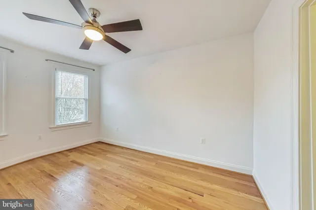 an empty room with a window and ceiling fan