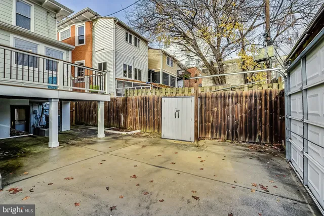 a view of a brick house with large windows and a small yard
