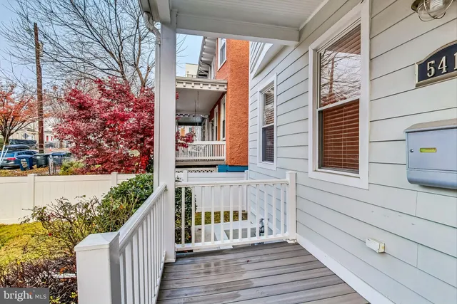 a view of a deck with wooden floor and fence next to a yard