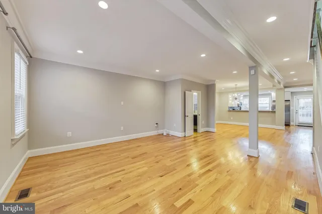 a view of an empty room with wooden floor