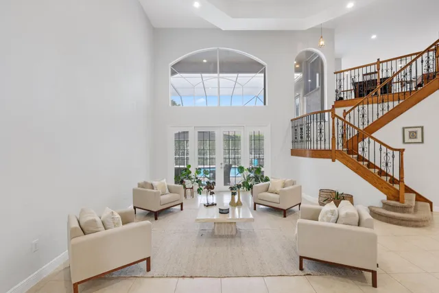 a living room with furniture a flat screen tv and a large window