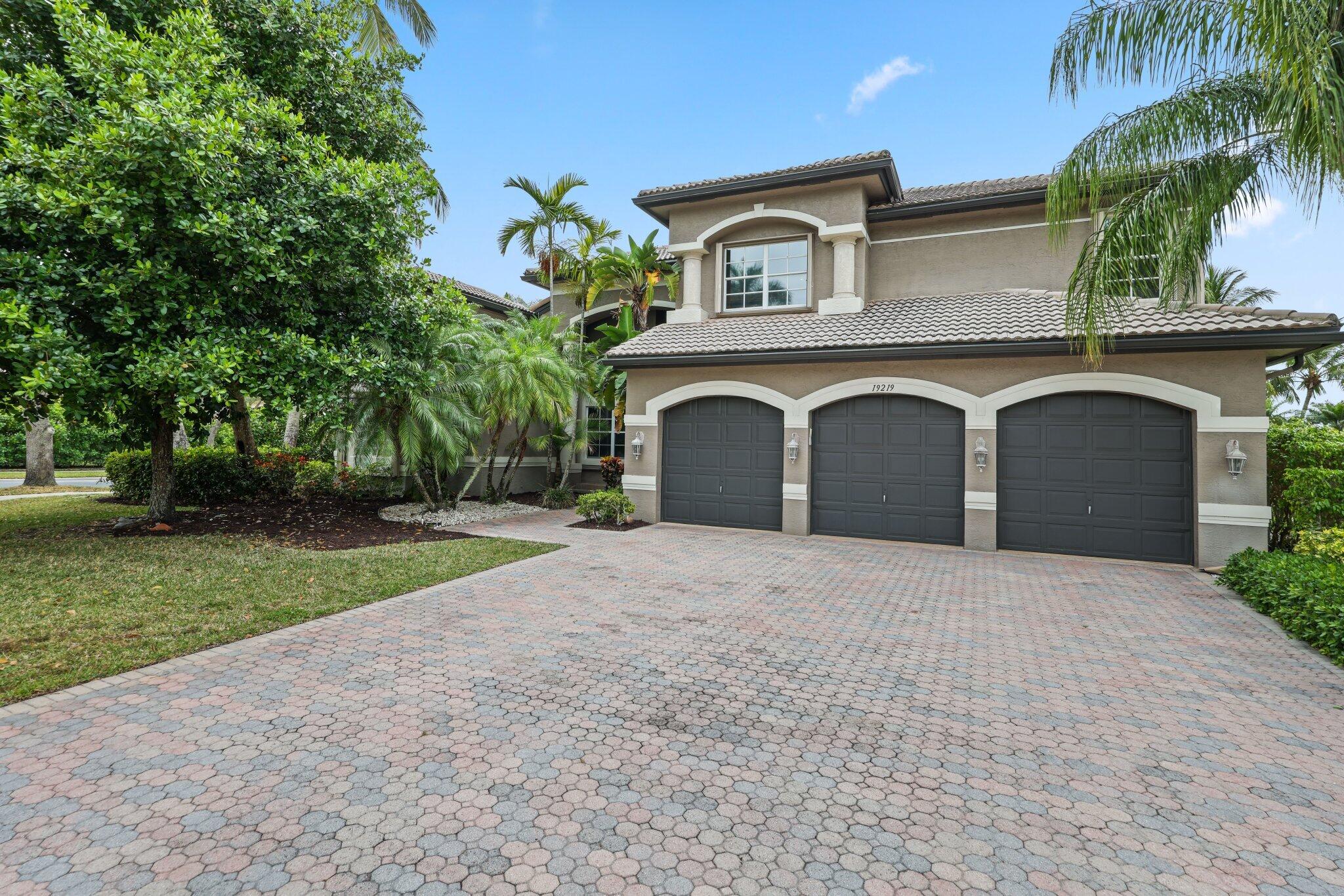 19219 North Creekshore Court Boca Raton, FL 33498 - Photo 5 of 73 a front view of a house with a yard and a garage