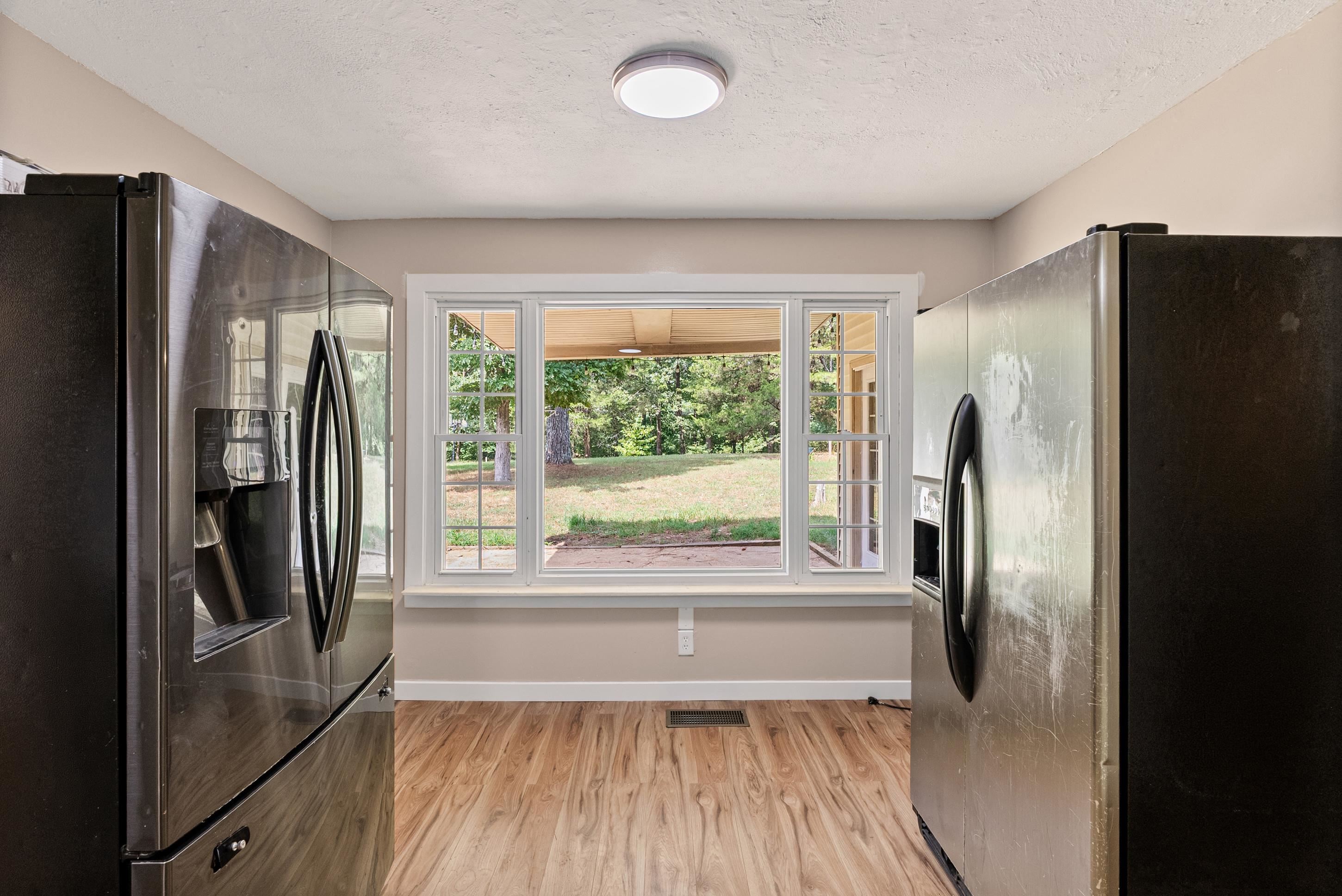 779 Strickland Road Coldwater, MS 38618 - Photo 13 of 40 Kitchen area featuring wood-finish flooring, a large window, and a flush-mount ceiling light