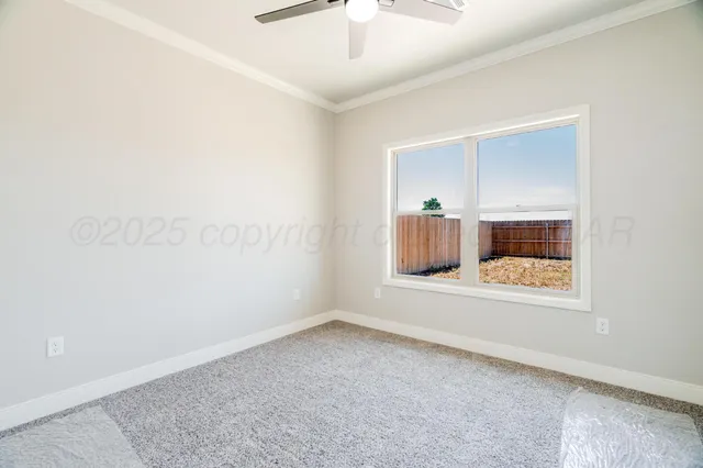an empty room with wooden floor and a ceiling fan