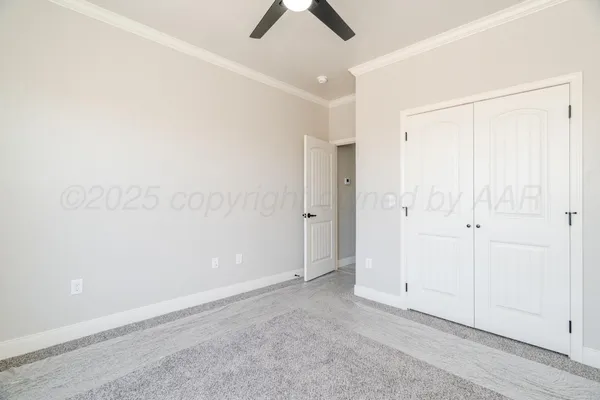 an empty room with chandelier fan