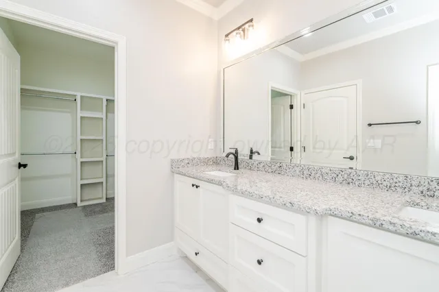 a bathroom with a granite countertop sink and a mirror