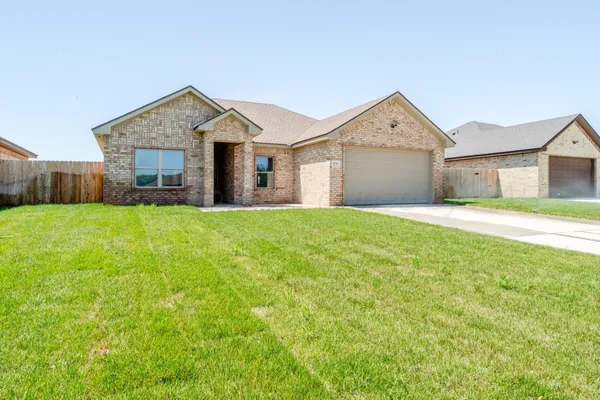 a front view of a house with yard and garage