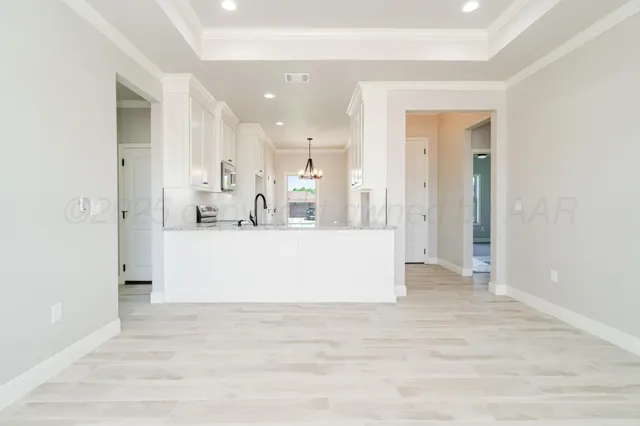 a view of kitchen with kitchen island a sink wooden floor and a refrigerator