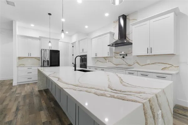 a kitchen with stainless steel appliances sink refrigerator and microwave