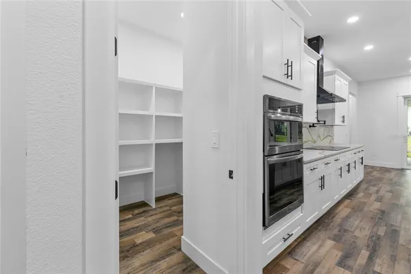 a view of a kitchen with cabinets and wooden floor
