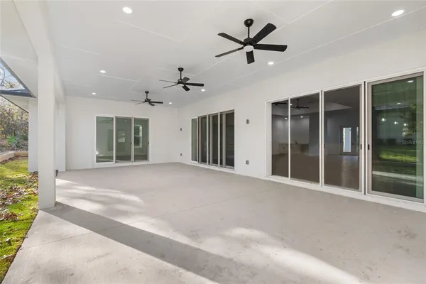 a view of an empty room with a ceiling fan and window
