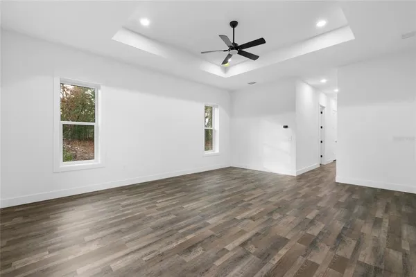 a view of a hallway with wooden floor and a bathroom