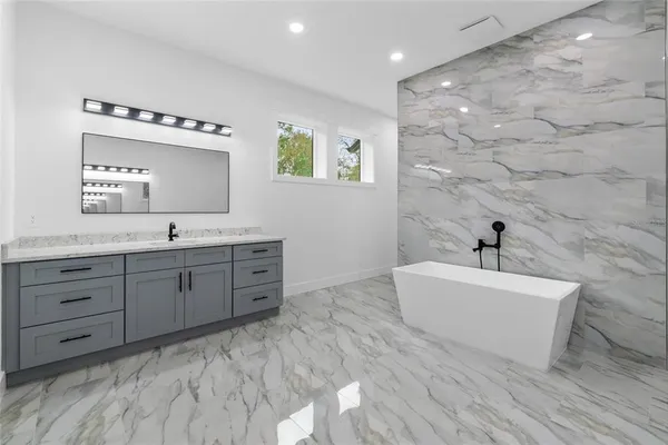 a bathroom with a tub sink and mirror