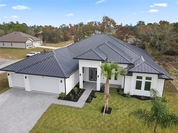 a aerial view of a house with pool and a yard