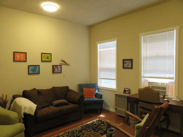 a view of a workspace with furniture and a window