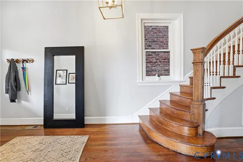 a view of a hallway with wooden floor and staircase