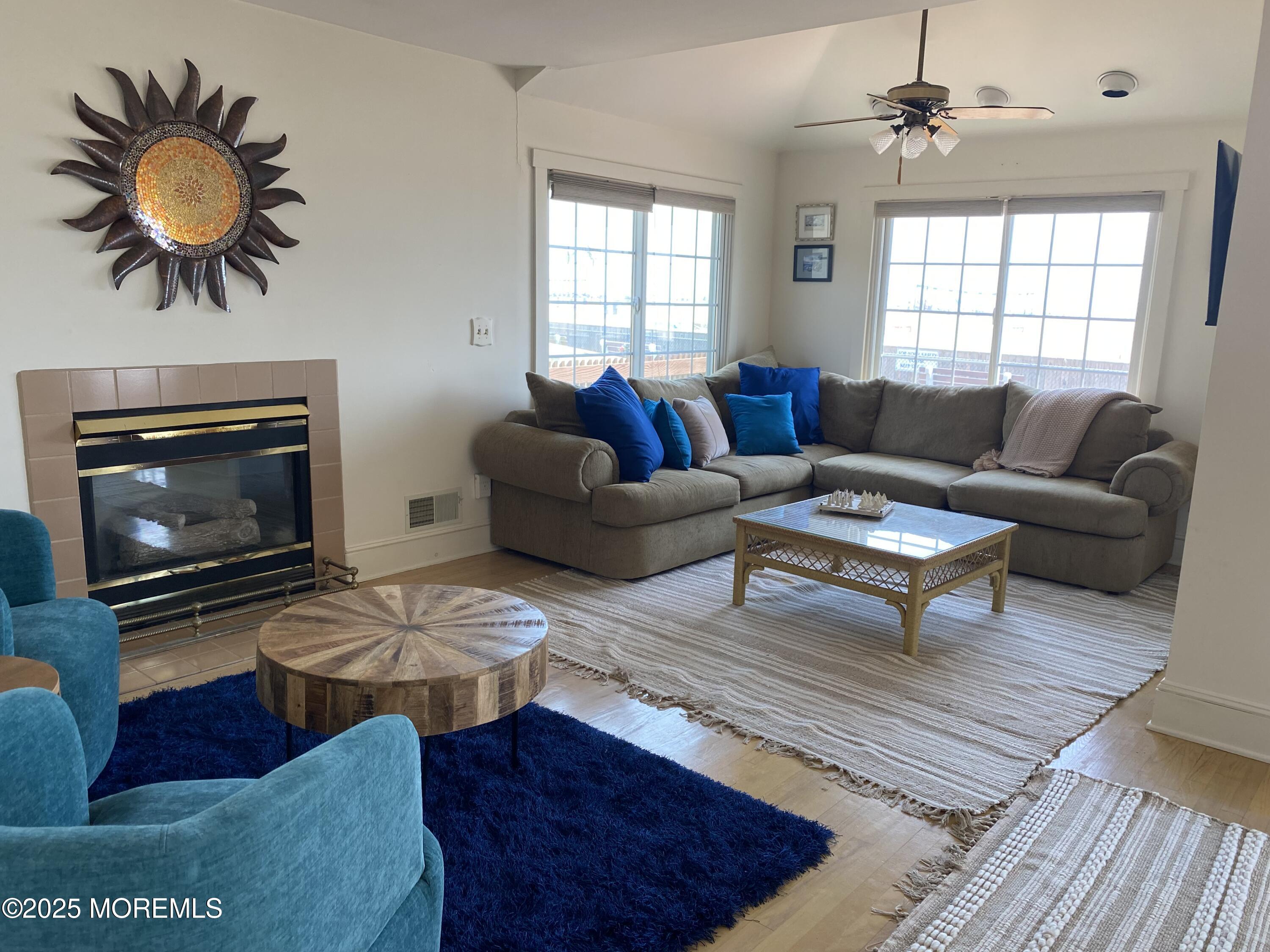 115 Boardwalk Point Pleasant Beach, NJ 08742 - Photo 16 of 23 a living room with furniture a chandelier and a fireplace