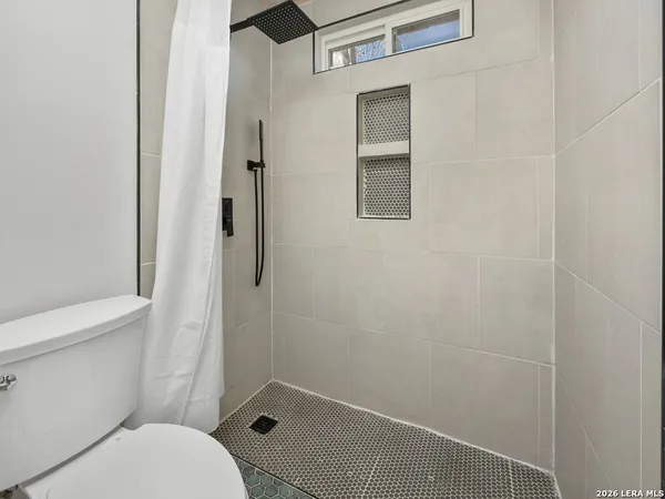 a bathroom with a toilet and a shower