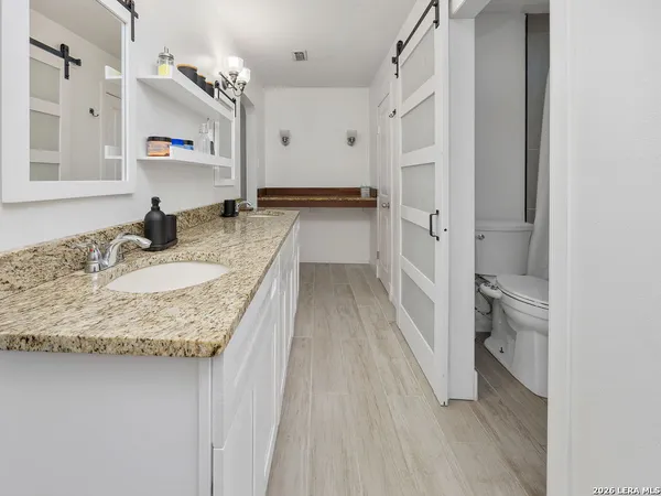 a bathroom with granite countertop a sink and a mirror
