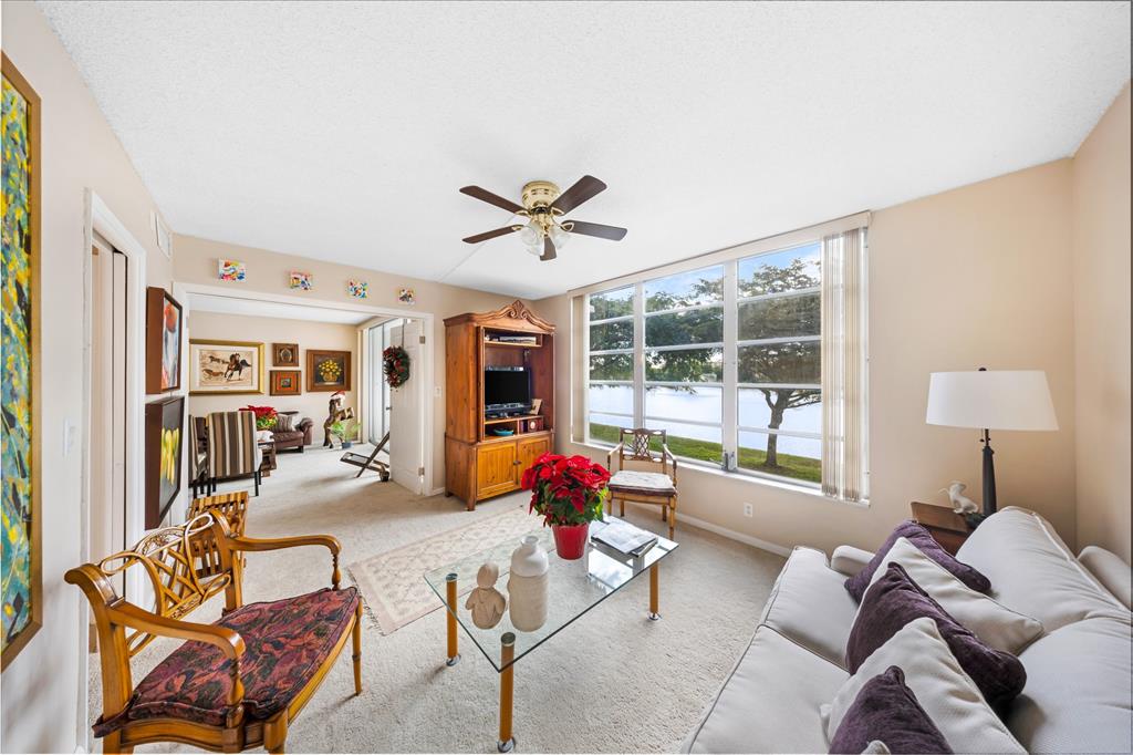 3150 North Course Lane, Unit 203 Pompano Beach, FL 33069 - Photo 14 of 26 a living room with furniture and floor to ceiling windows