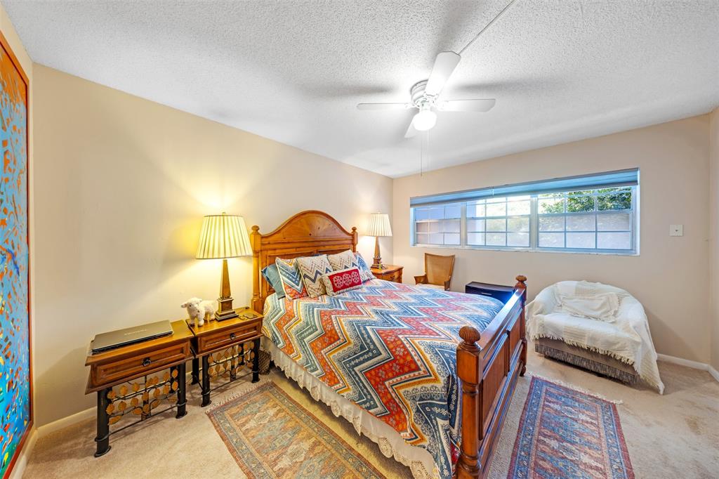 3150 North Course Lane, Unit 203 Pompano Beach, FL 33069 - Photo 19 of 26 a bedroom with a bed and a chandelier