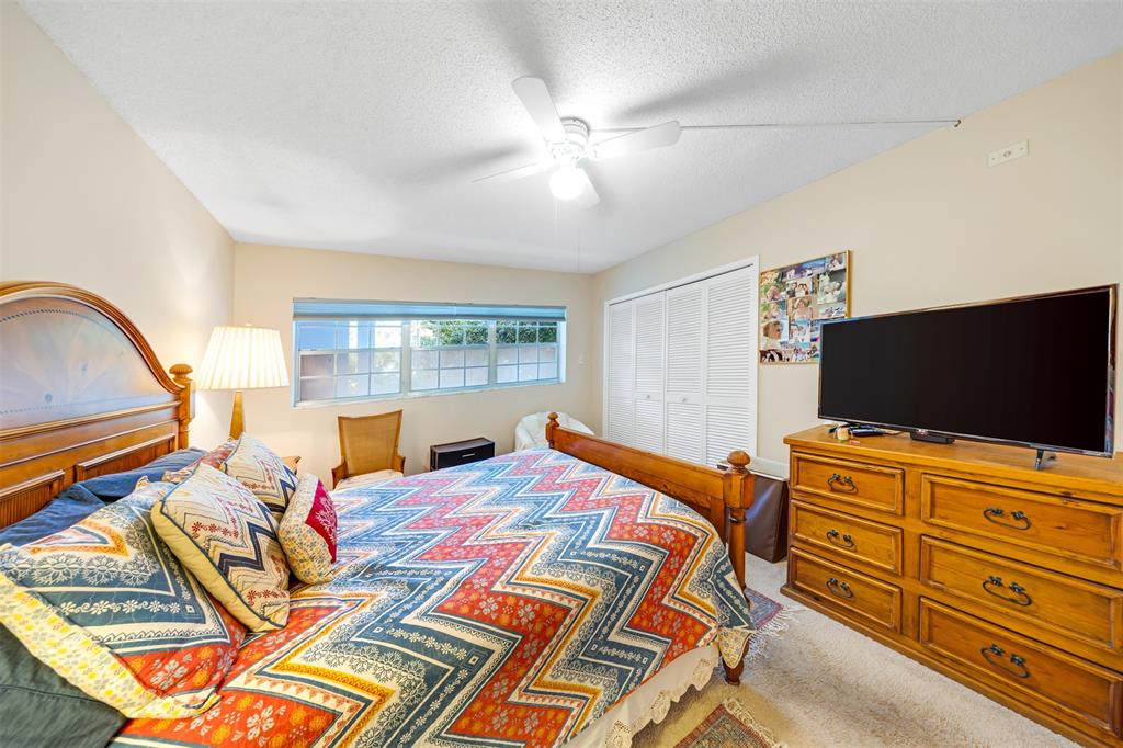 3150 North Course Lane, Unit 203 Pompano Beach, FL 33069 - Photo 20 of 26 a bedroom with a bed and flat screen tv