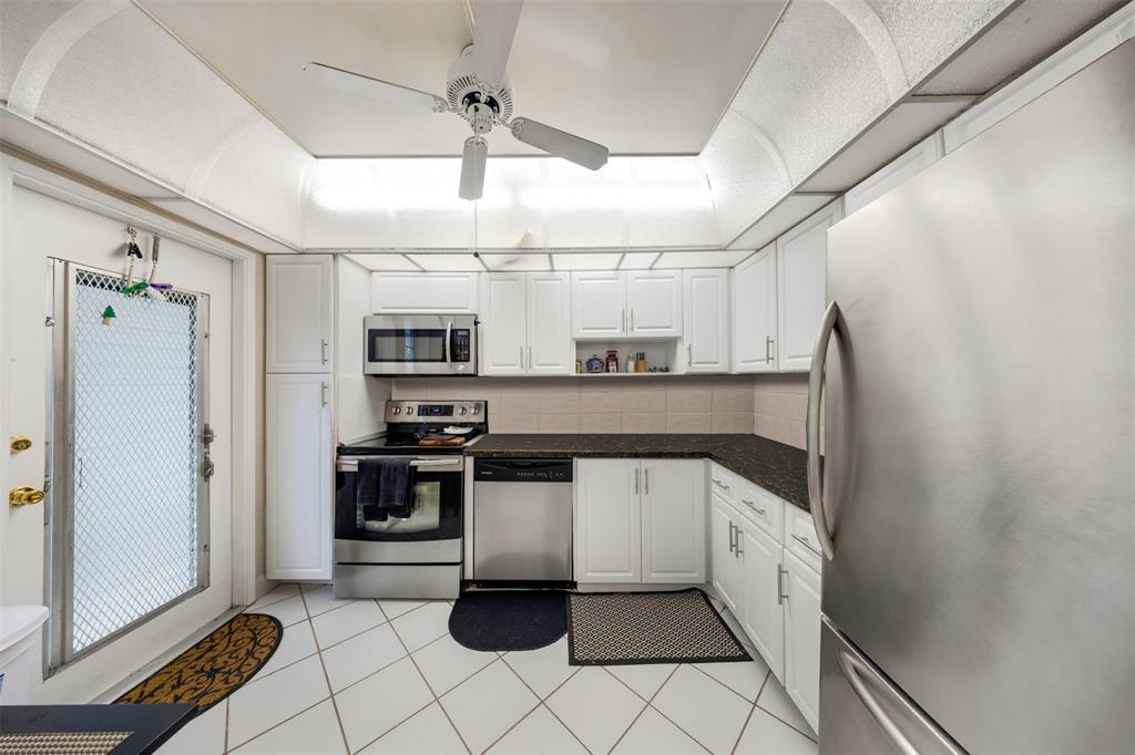 3150 North Course Lane, Unit 203 Pompano Beach, FL 33069 - Photo 2 of 26 a kitchen with stainless steel appliances a refrigerator and a stove