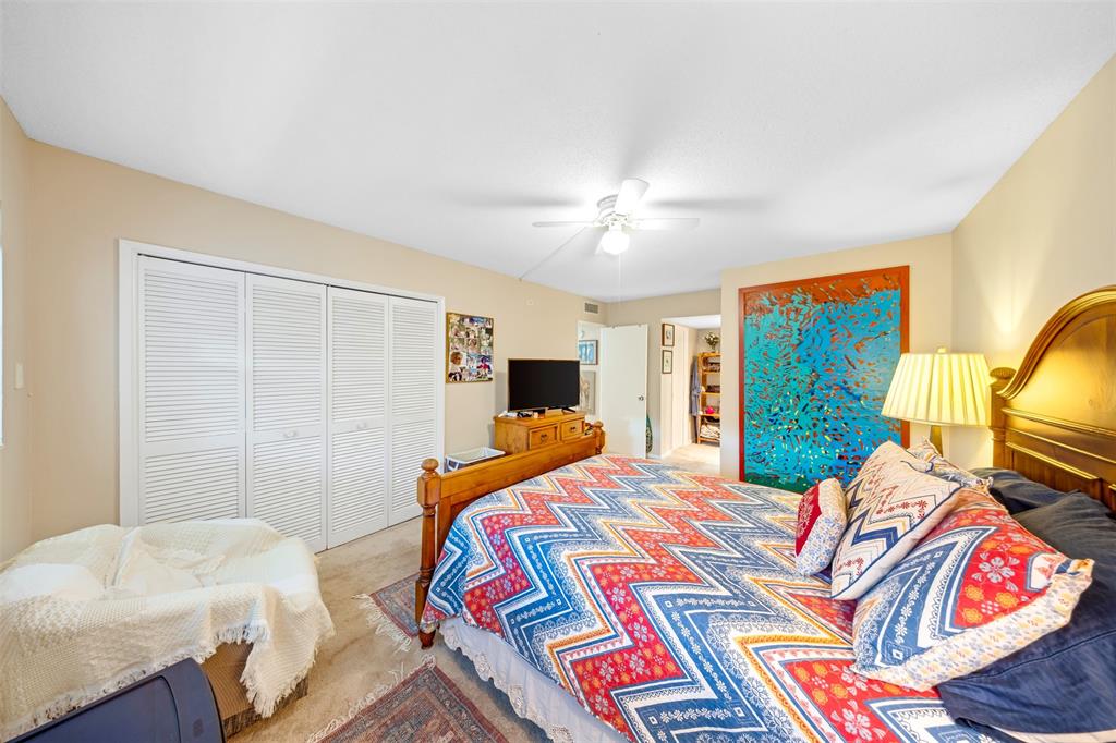 3150 North Course Lane, Unit 203 Pompano Beach, FL 33069 - Photo 21 of 26 a bedroom with a bed and wooden floor