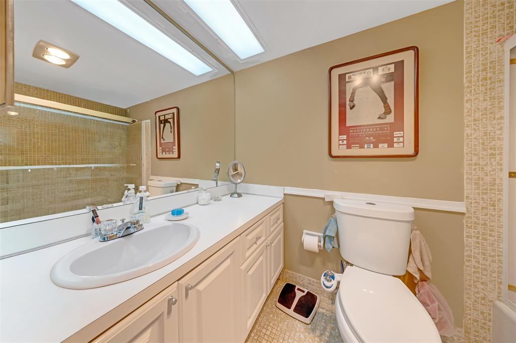 3150 North Course Lane, Unit 203 Pompano Beach, FL 33069 - Photo 23 of 26 a bathroom with a toilet sink and mirror