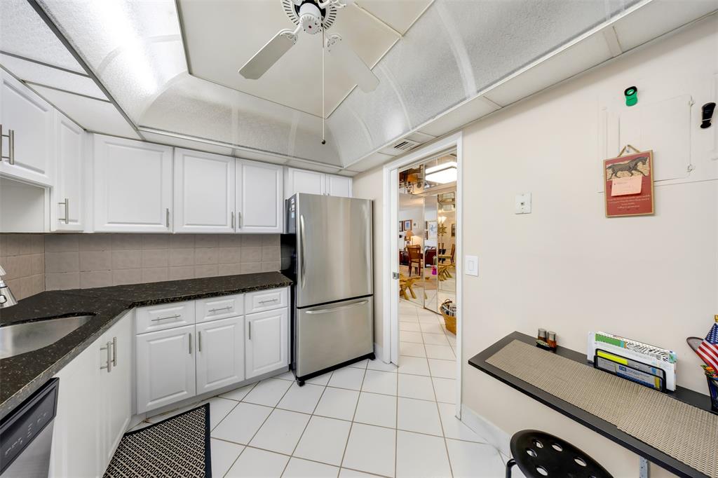 3150 North Course Lane, Unit 203 Pompano Beach, FL 33069 - Photo 5 of 26 a kitchen with granite countertop a refrigerator and a sink
