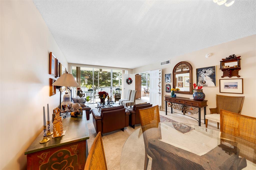 3150 North Course Lane, Unit 203 Pompano Beach, FL 33069 - Photo 7 of 26 a living room with fireplace furniture and a large window