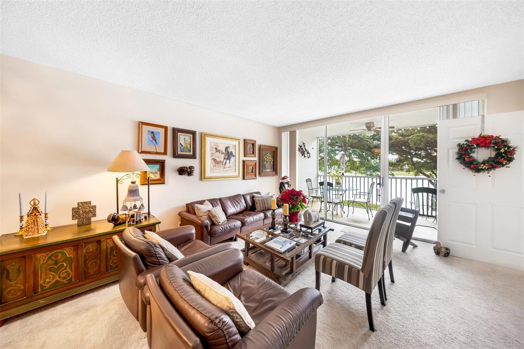 3150 North Course Lane, Unit 203 Pompano Beach, FL 33069 - Photo 9 of 26 a living room with furniture and a floor to ceiling window