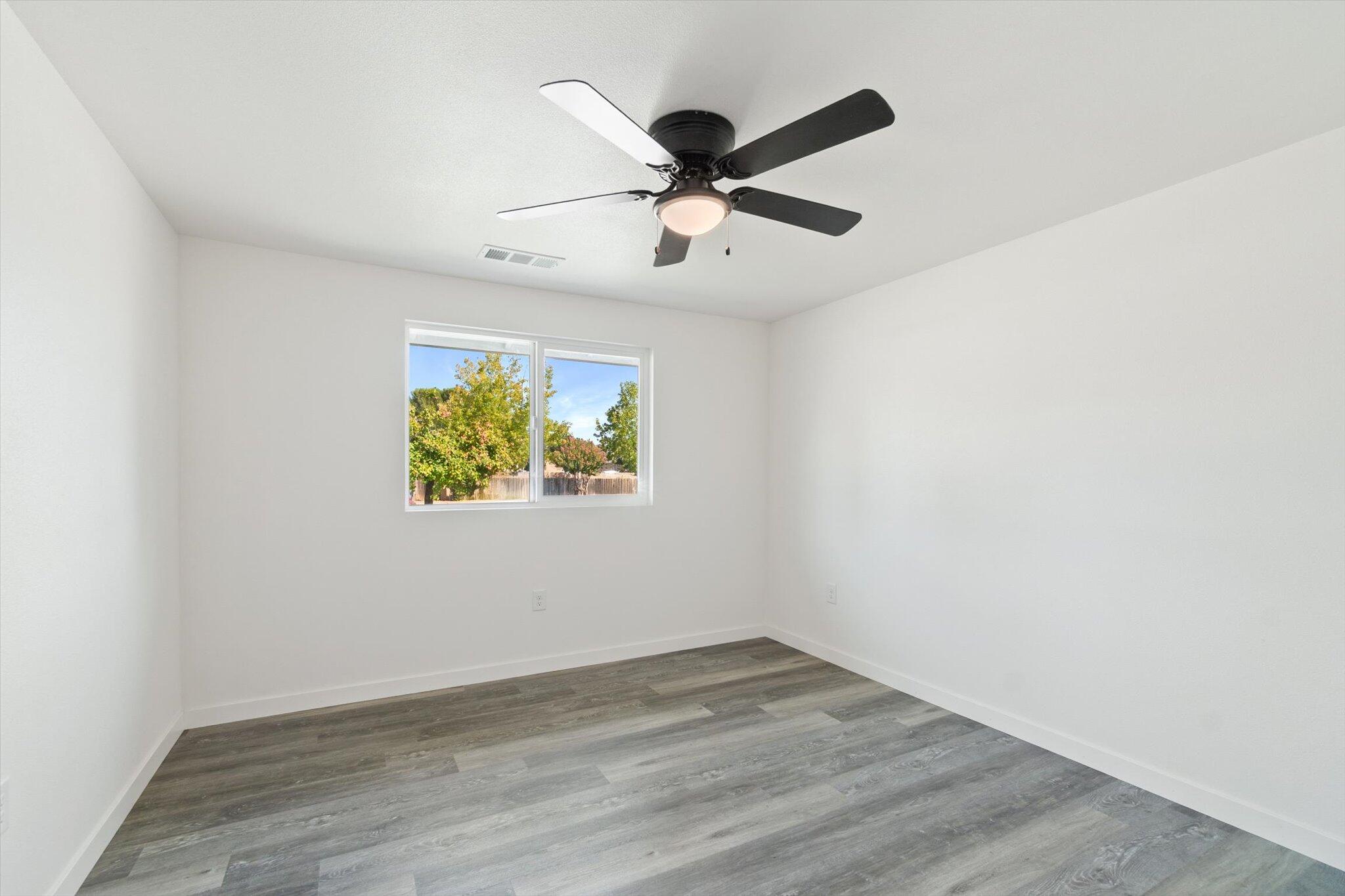 3276 School Street Redding, CA 96002 - Photo 13 of 36 an empty room with wooden floor and ceiling fan