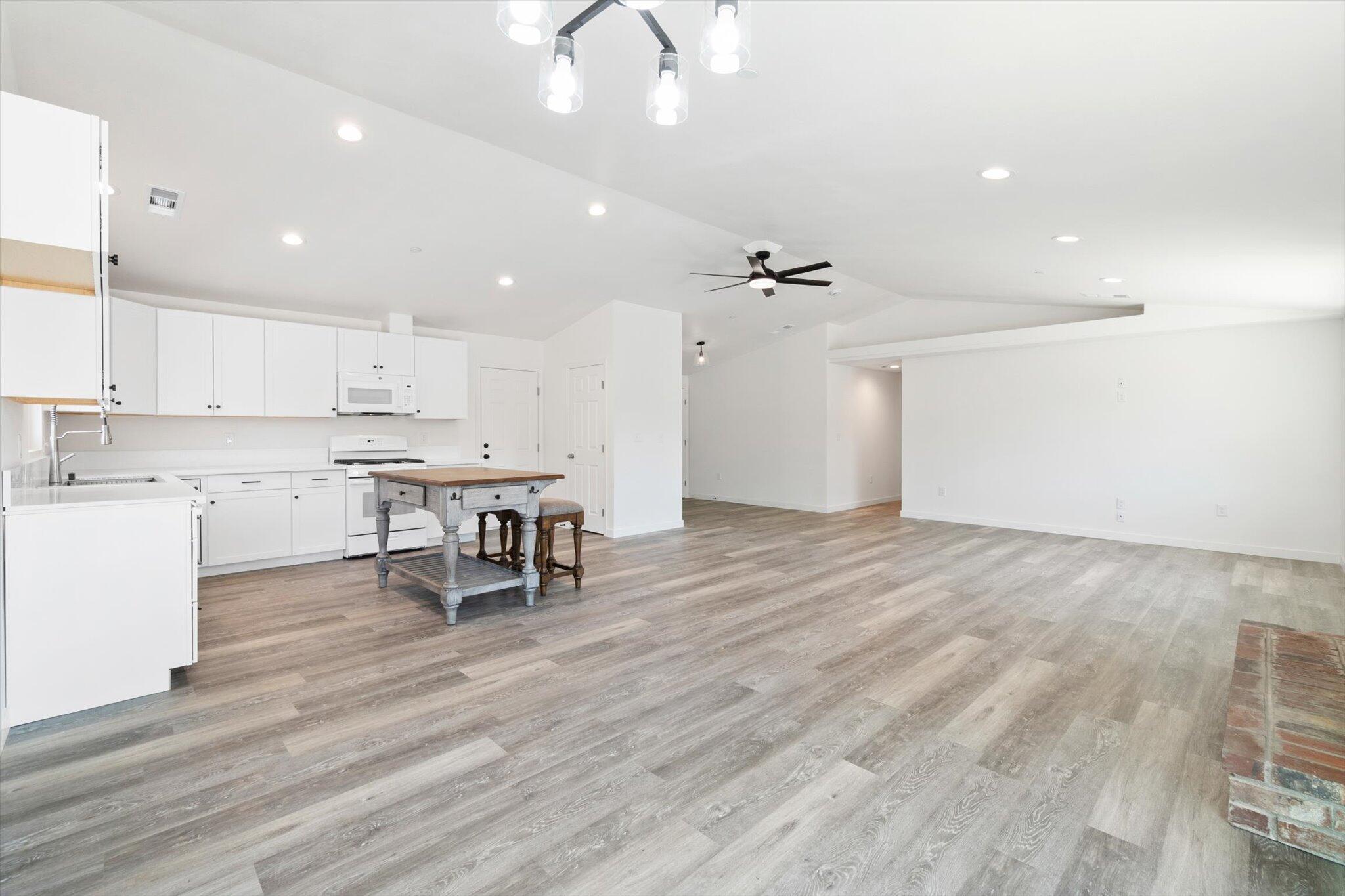 3276 School Street Redding, CA 96002 - Photo 3 of 36 an open kitchen with kitchen island white cabinets and stainless steel appliances