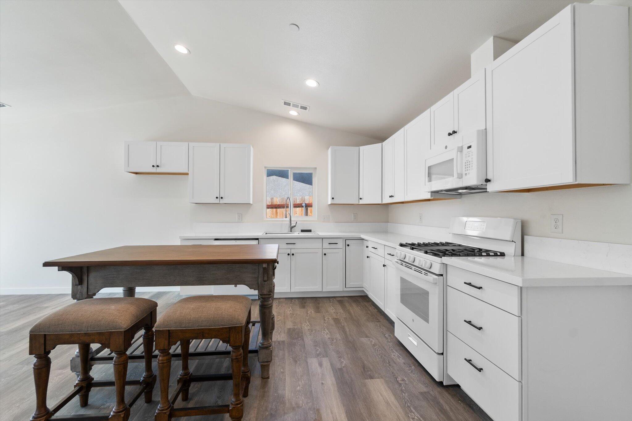 3276 School Street Redding, CA 96002 - Photo 4 of 36 a kitchen with granite countertop a table chairs stove and cabinets