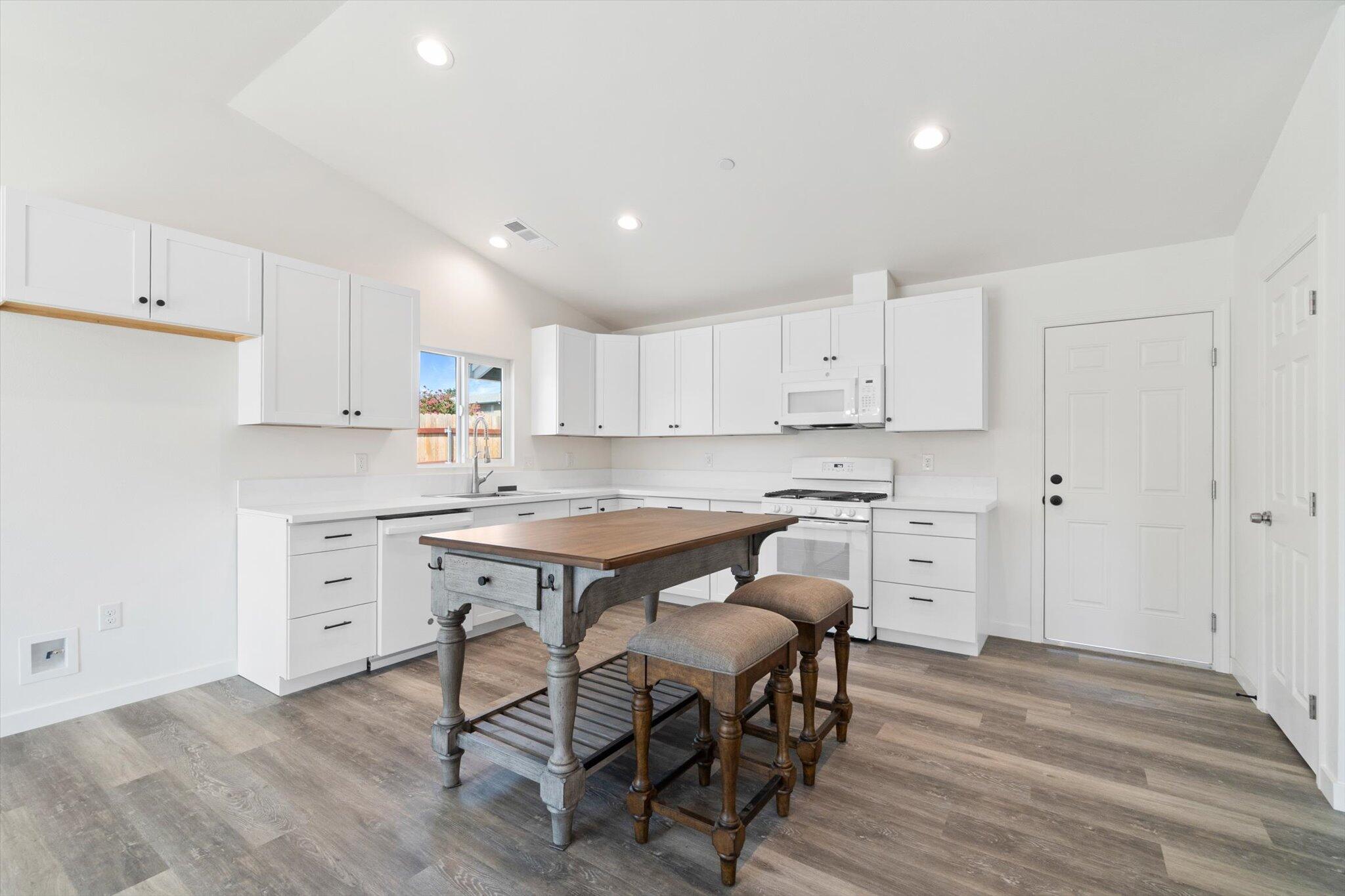 3276 School Street Redding, CA 96002 - Photo 5 of 36 a kitchen with white cabinets and white appliances