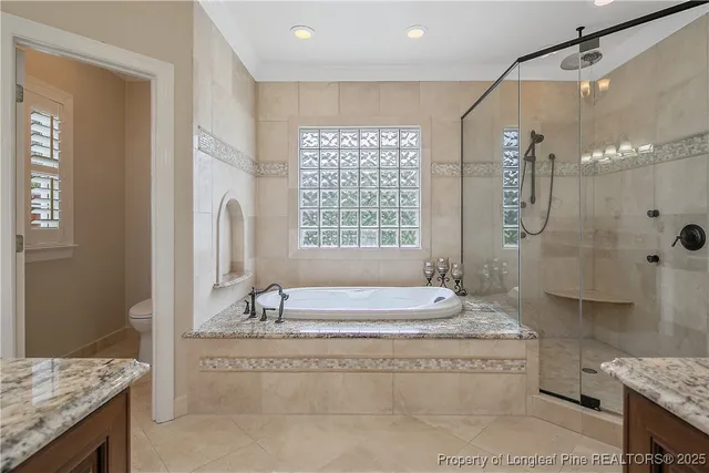 a spacious bathroom with sink shower bathtub and window