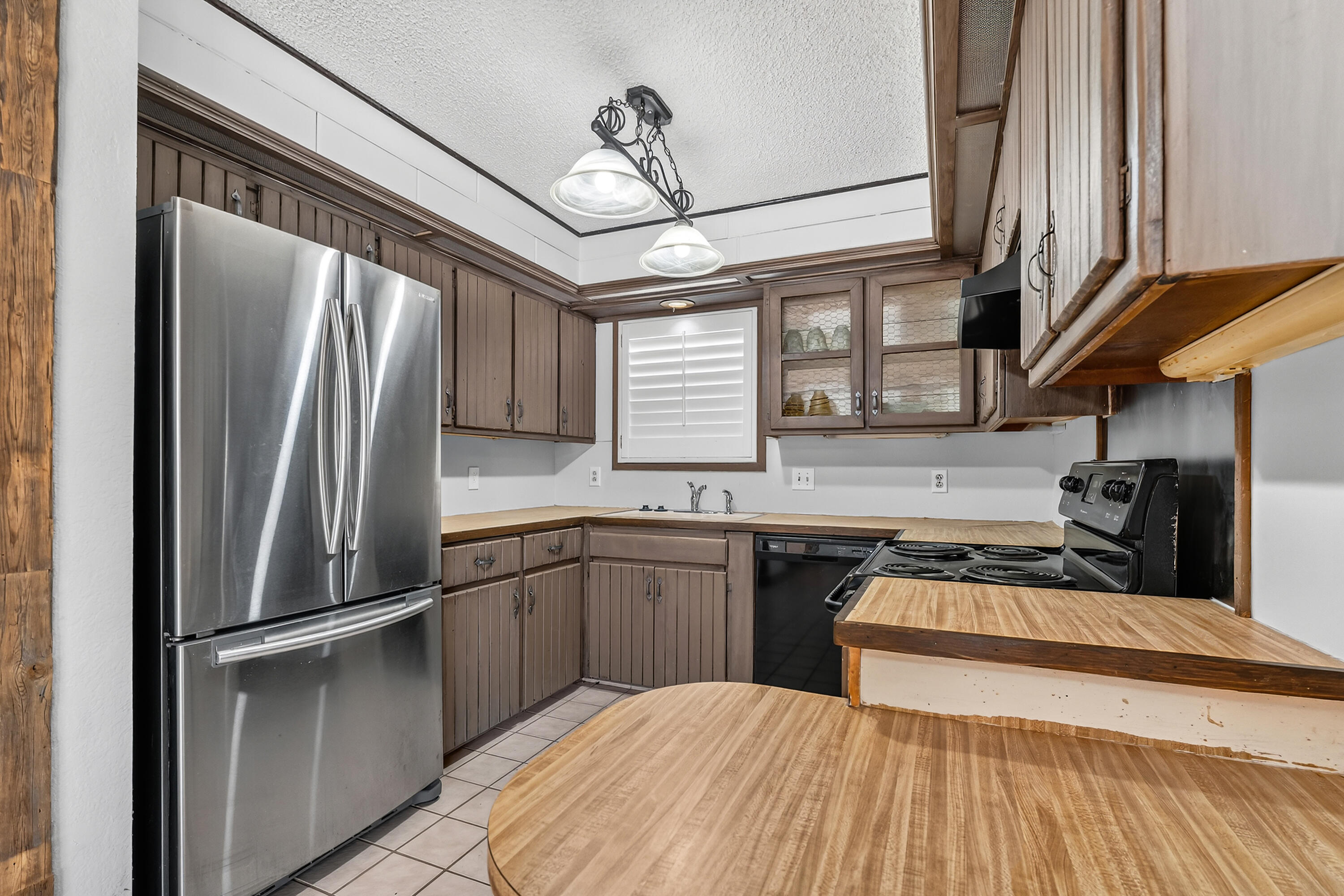 5236 91st Street Lubbock, TX 79424 - Photo 10 of 23 a kitchen with stainless steel appliances granite countertop a refrigerator a sink dishwasher a stove and white countertops with wooden floor