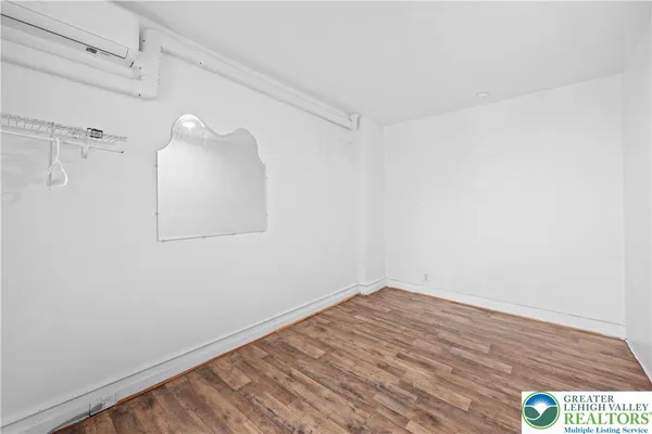 a view of a small space with wooden floor and a window