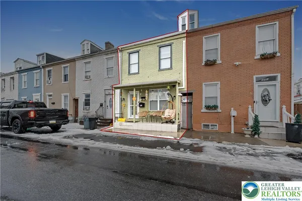 a front view of a house with cars parked