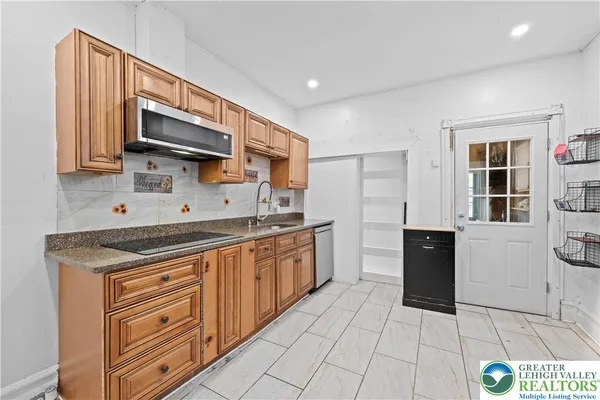 a kitchen with stainless steel appliances granite countertop a sink and a stove
